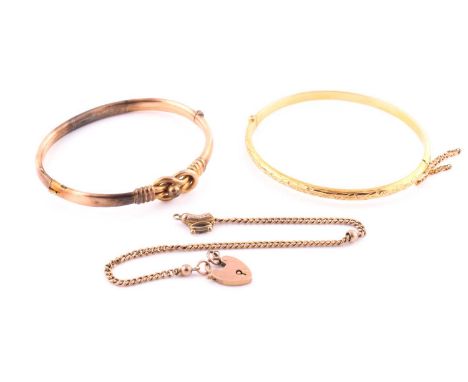 A 9 carat gold hollow bracelet; foliate engraved to one side with hinged opening and push button clasp; a further 9 carat gol