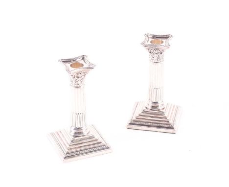 A pair of Corinthian column candlesticks, Sheffield 1999, by Mappin and Webb, of traditional form on stepped square bases, wi