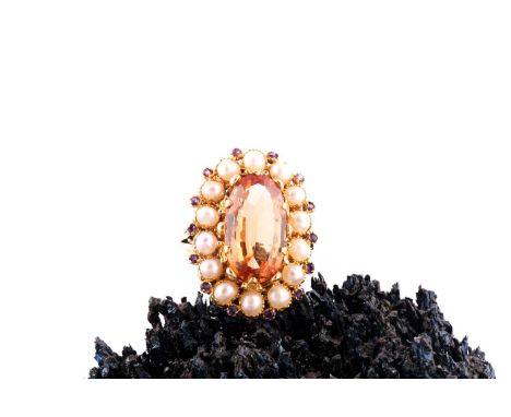 A topaz, seed pearl and amethyst ringThe oval-shaped topaz, measuring approximately 17.9mm x 9.9mm x 5.2mm, decorated with fl
