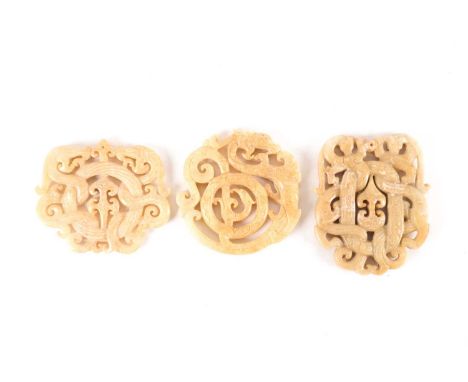 A Chinese carved and pierced circular pale yellow jade amulet, with scrolling dragon and phoenix, 7 cm diameter; a similarly 