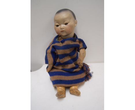 An Armand Marseille bisque head Oriental baby doll, with spray painted hair, sleeping brown glass eyes and closed mouth, body