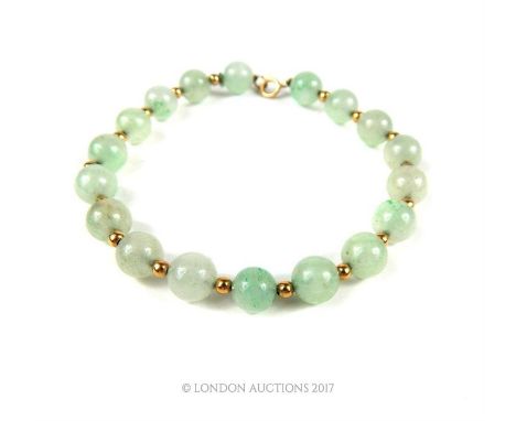 A jade beaded bracelet with14 carat gold spacers. 19 cm long 