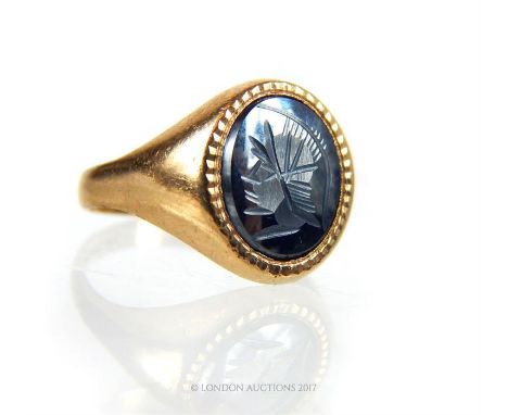 9ct gold intaglio carved hematite ring, the hematite carved with the profile of Mars, Size R 1/2.