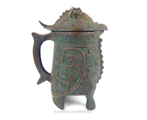 A bronzed, white metal lidded jug in the ancient South American style featuring decorative, Mayan iconography and an overall 