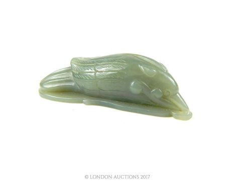 A Chinese carved jade bird figure resting upon a carved leaf, 2.5 x 8 x 3cm.