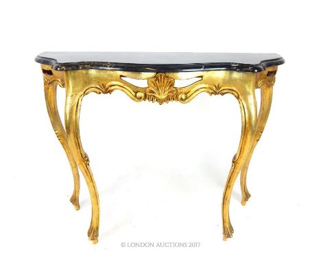 A giltwood console table, having a serpentine marble top, over a carved shell frieze, raised on carved cabriole supports, 82 