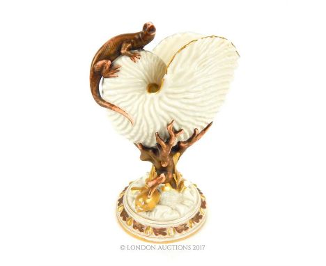 A Royal Worcester porcelain spoon warmer, in the form of a Nautilus shell, with gilded highlighted edges raised on a naturali