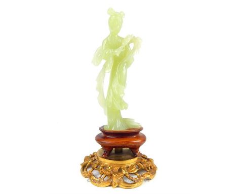 A fine, 19th century carved translucent green jade standing figure of the goddess Guanyin, with flowing robes, head -dress an