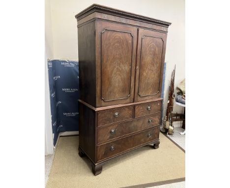 A 19th Century mahogany linen press, the dentil cornice over two figured panelled doors, opening to reveal a hanging space (f