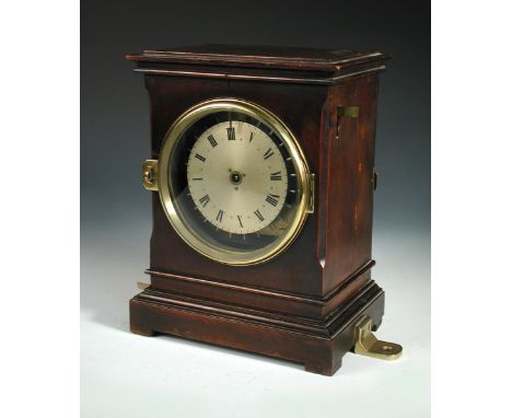 A late 19th century walnut cased and brass mounted Watchman's mantle clock, the silvered dial with central winding mechanism,