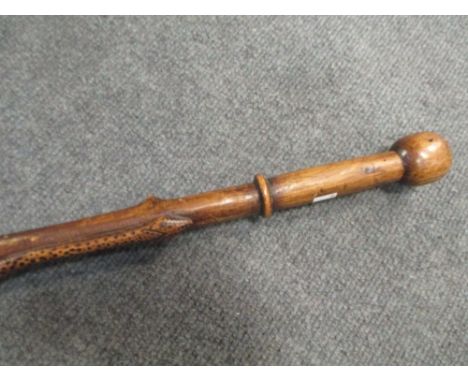 An African walking stick, early 20th century, carved with an entwined snake  