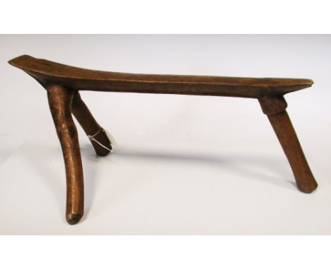 A hardwood tripod stool, Pokot people, Kenya, carved from a natural tree growth, the underside with a central ridge, 45cm (17