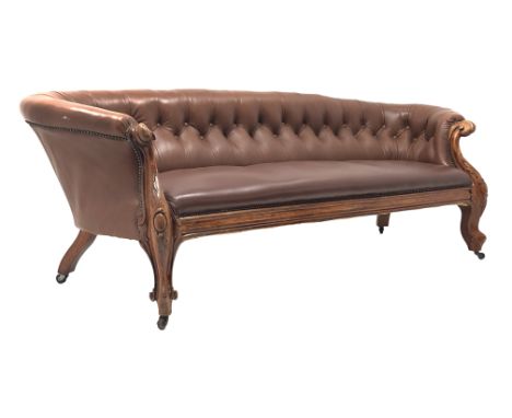 Late 19th century carved walnut framed nailed brown leather  upholstered Chesterfield sofa, with deep buttoned back, leaf car