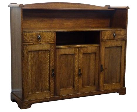 Arts & Crafts oak sideboard, raised arched back with single shelf, above two drawers, four cupboards and a recess, with brass