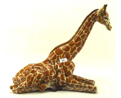 A large 20th century painted ceramic figure of a Giraffe, in a resting pose, label to base reads Di Lieto, Italy,  45cm high
