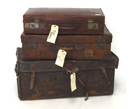 A vintage leather trunk and two suitcases, the trunk with side handles, measuring 34cm x 80cm x 40cm