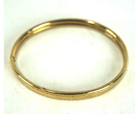 A 9ct gold bangle, with engraved decoration, 5.9g