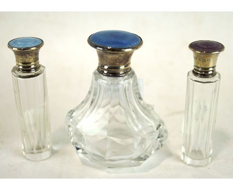 Three enamel topped silver mounted glass scent bottles, the largest measuring 8cm high
