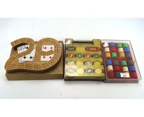 A collection of contemporary casino counters and a cribbage board, all in the original boxes