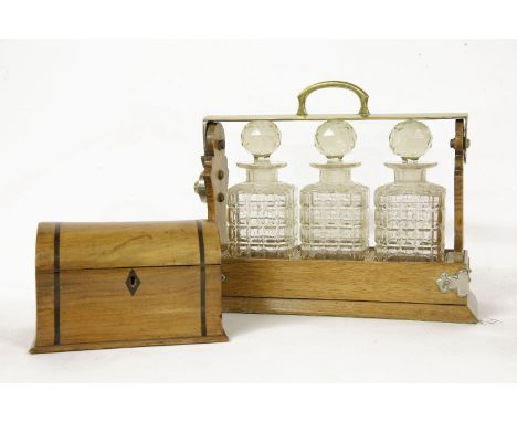 A three bottle tantalus, and a dome top tea caddy