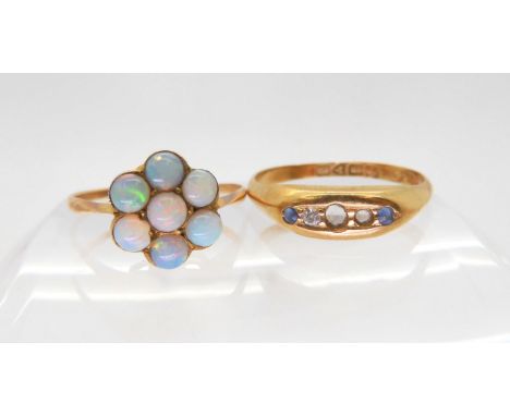 An 18ct gold five stone ring (af) hallmarked Chester 1912, size O1/2, and a yellow metal mounted opal flower ring, size O1/2 