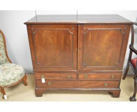 A Georgian mahogany dwarf linen press, the rectangular moulded top above a pair of panelled doors with later pull-out trays, 