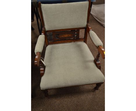 An Edwardian mahogany parlour chair, upholstered in green, the padded back with inlaid mid-rail and scroll arms, raised on tu