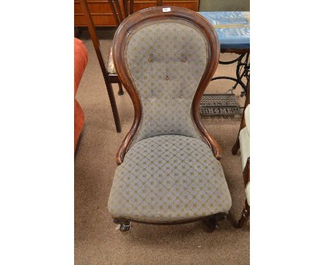 A Victorian mahogany spoon back nursing chair, with deep button back and padded seat, raised on cabriole legs and whorl feet.