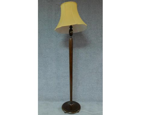 A mid 20th century teak standard lamp with lemon shade. H.180 