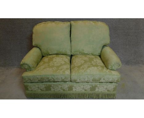 A two seater sofa in floral green upholstery. 97x145x80cm 