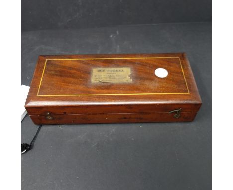 A cased Sikes' hydrometer, with brass weights, and thermometer marked 'W.R. Loftus, London W.', W.25 D.11cm 