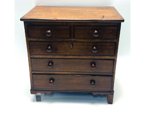 An early 19th century miniature mahogany chest of two short over three long drawers, with back line inlay to the drawers and 