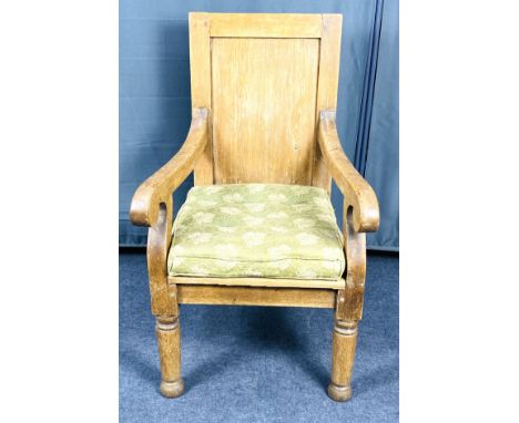 A late 19th century large pale oak open armchair of simplistic design and form, with scrolling arms and a fielded panel back,