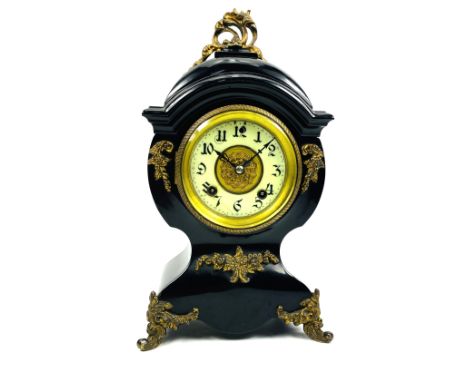 A ebonised metal cased French balloon form mantle clock with decorative gilt brass mounts throughout, pendulum present, circa