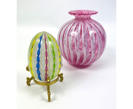 A Murano style colourful glass egg with air twist decoration, 5cms wide x 8cms high, complete with a gilt metal stand; togeth