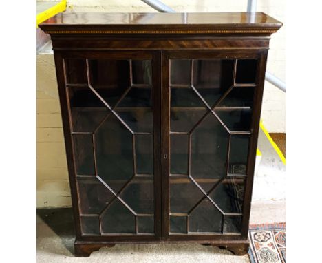 A 19th century inlaid mahogany bookcase with a pair of glazed astragal glazed doors and interior adjustable shelves, and rais