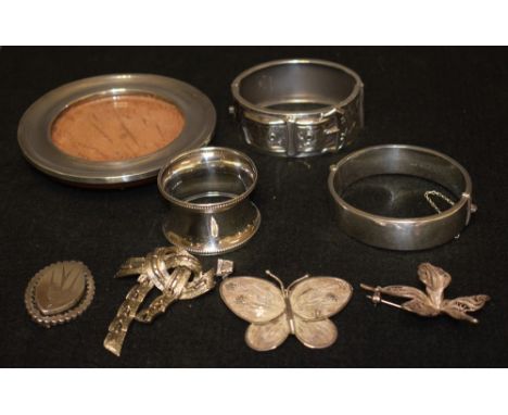 An early 20th century silver buckle bracelet, Birmingham 1937; a silver circular photo frame; a silver hinged bangle; a silve