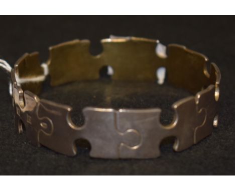 A silver jigsaw pieces solid body bangle, H&Co, Birmingham 1994, 48.4g 