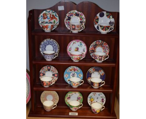 A set of twelve Royal Worcester miniature collector's cups and saucers on display stand with certificates, The Golden Age Of 