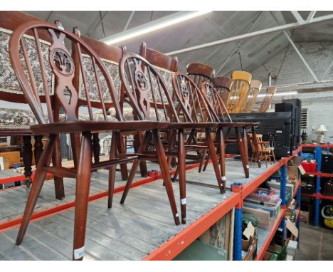A set of four Ercol dark elm 'Fleur de Lis' dining chairs. 
