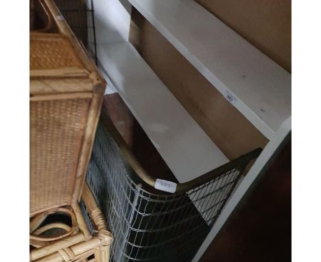 A 19th century fireguard and a white painted bookshelf.