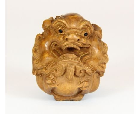 A carved wooden netsuke of a young dragon with onyx eyes H 5cm