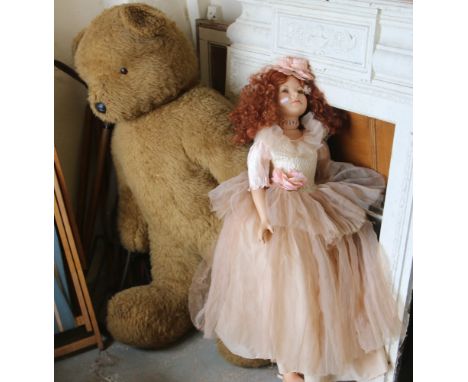 A large bisque headed collectors doll along with a large teddy bear.