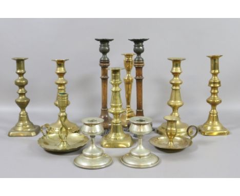 A collection of mainly brass candlesticks to include side plate, turned ash and chamber stick examples.