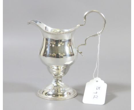 A Georgian silver cream jug with scrolling handle, assayed London 1778, 106.5 grams.