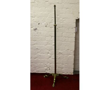 A brass rise and fall standard lamp on tripod base.