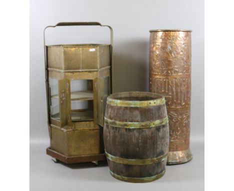 A large eastern copper stick stand along with a hexagonal brass street sellers box and a wooden barrel.