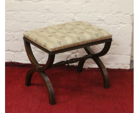 A mahogany Regency style X framed foot stool with turned stretcher.
