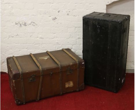 A large wooden bound students travel trunk along with another metal bound students trunk.