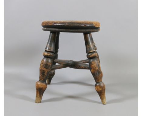 A small antique kitchen stool raised on turned supports.